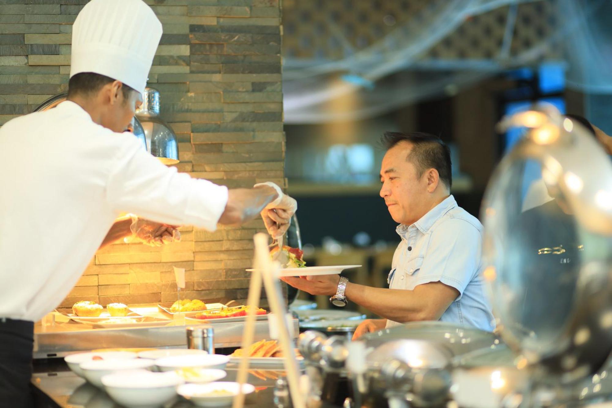 Ramee Grand Hotel And Spa Manama Exterior photo A chef serving food at a buffet